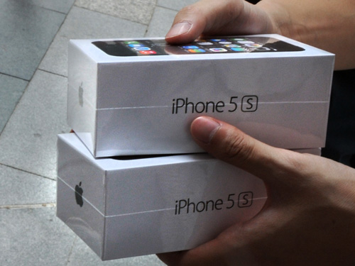 A reseller (L) buys new iPhone 5s handsets from a new iPhone owner (R) outside an Apple store in Hong Kong on September 20, 2013. Apple acolytes got their hands on new iPhones in the global roll-out of two new models, but failure to make headway in China and complaints about the price struck a sour note. Dozens of resellers, hoping to sell the phones to people who were not able to pre-order the phone, crowded the stores in Central and in the shopping district of Causeway Bay. AFP PHOTO / Laurent FIEVET (Photo credit should read LAURENT FIEVET/AFP/Getty Images)